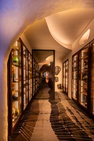 El pasillo de las vitrinas de vino de Arko, con una puerta de espejo al fondo